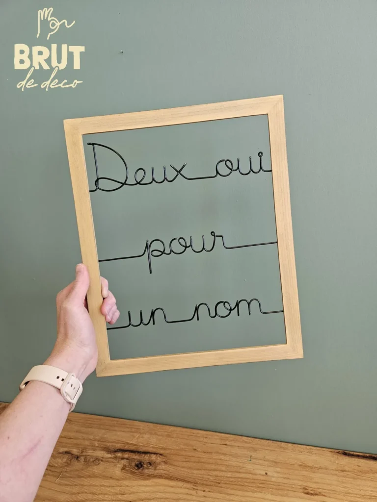 Cadre bois, phrase "deux oui pour un nom" en fil aluminium - Brut de deco